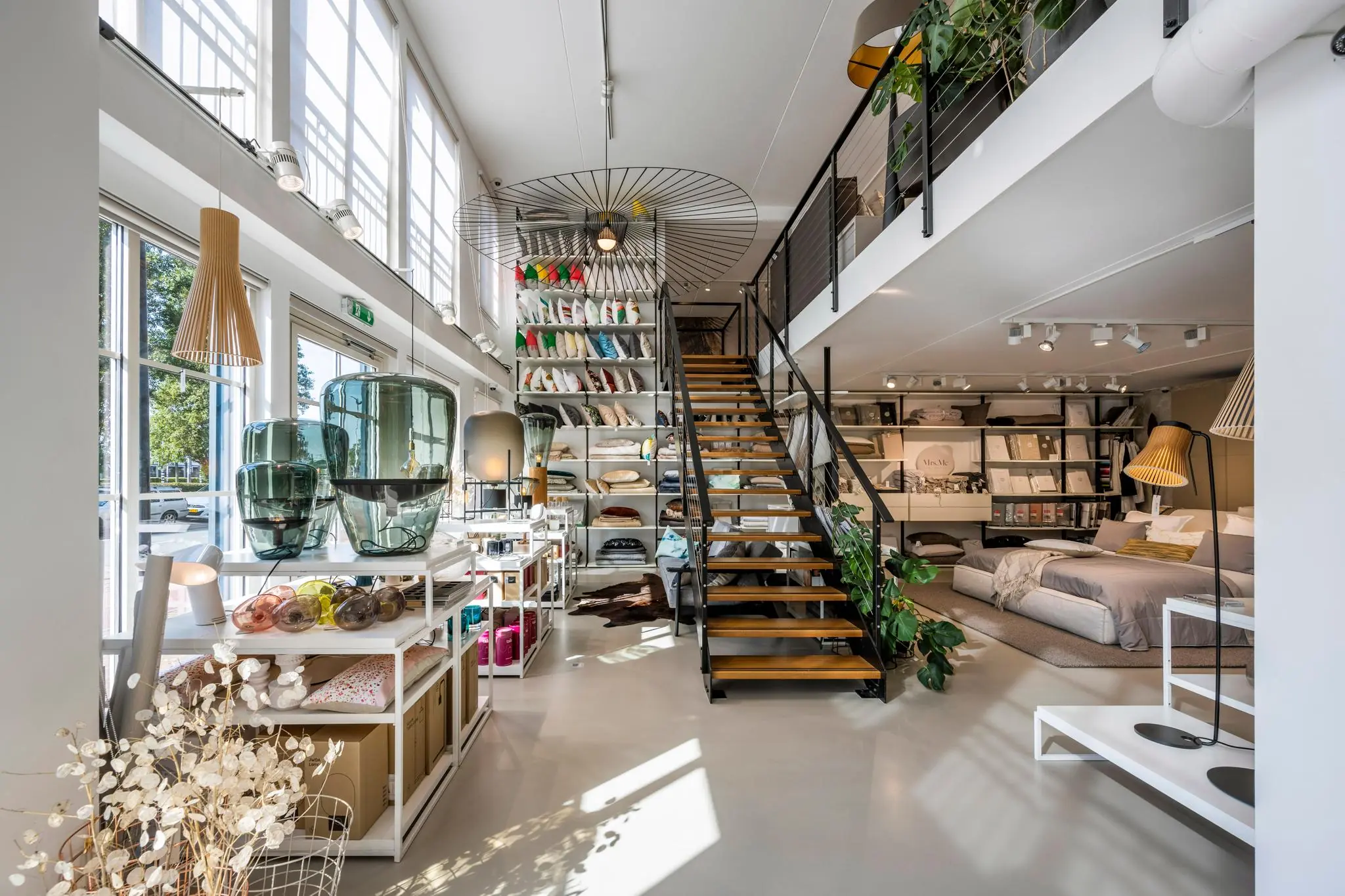 Interieur van een modern ingerichte woonwinkel aan de Oostelijke Handelskade met beddengoed, kussens en designaccessoires.